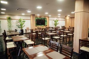 a restaurant with tables and chairs in a room at Hospedare Hotel in Marechal Cândido Rondon