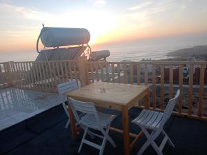a table and chairs on a balcony with a camera at Atlantic Coast Imsouane in Imsouane