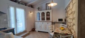 a kitchen with a table and a white cabinet at Apartments Gabri in Mali Lošinj