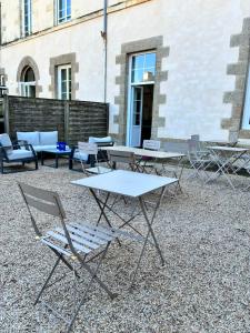 a group of tables and chairs in front of a building at Hôtel de Bretagne in Redon