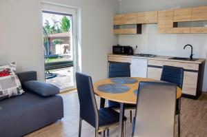 a kitchen and a table and chairs in a room at Apartamenty Suchacz in Suchacz