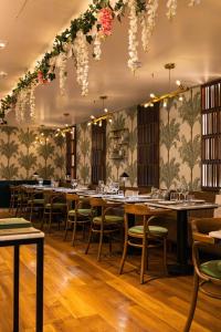 a dining room with tables and chairs and floral wallpaper at Hotel Florescente in Lisbon