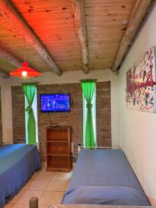 a bedroom with green curtains and a bed and a tv at Cabañas Las Marias in San Luis +19 photos
