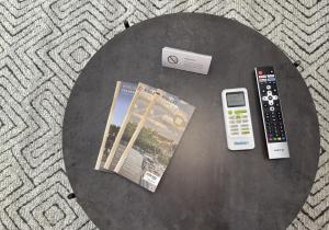a table with a newspaper and a remote control at JAM Suite in Koblenz
