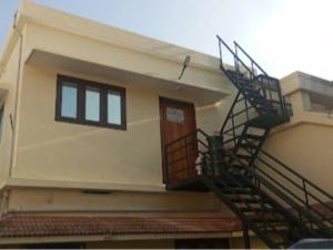 a house with a staircase leading to a door at Dream Stay in Varkala