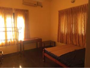 a bedroom with a bed and a window and a desk at Dream Stay in Varkala
