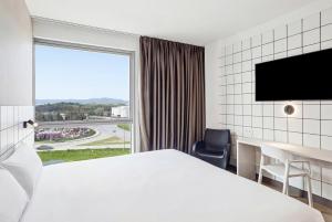 a hotel room with a bed and a desk and a window at B&B HOTEL Miranda de Ebro in Rivabellosa
