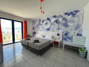 a bedroom with a bed and a painting on the wall at Bouradanis Art Hotel in Marmari