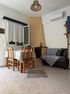 a living room with a table and chairs and a bed at Stegna Sunny-Beach in Archangelos
