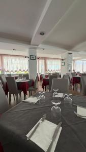 a dining room with tables and chairs with a table sidx sidx sidx at Hotel Gattei in Rimini