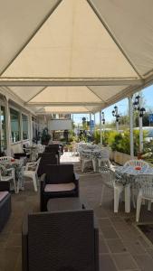a restaurant with tables and chairs and a large umbrella at Hotel Gattei in Rimini
