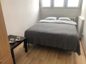 a bed in a room with two cups on a table at Inżynierska R1 in Wrocław