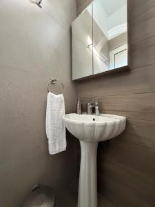 a bathroom with a white sink and a mirror at Stegna Sunny-Beach in Archangelos +23 photos