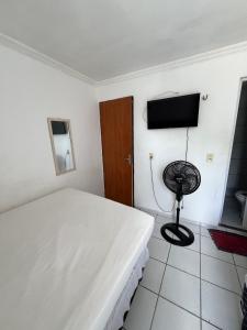 a bedroom with a bed and a flat screen tv at Pousada Iracema Centro in Fortaleza