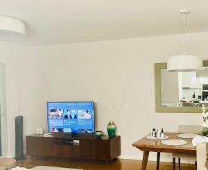 a living room with a tv and a table at Principality Apartment in Cardiff