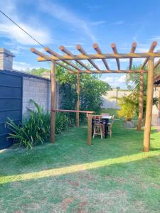 a wooden pergola with a table in a yard at Recanto das Palmeiras hidro in Hidrolândia