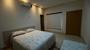 a bedroom with a bed and a window and a door at Recanto das Palmeiras hidro in Hidrolândia