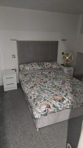 a bedroom with two beds with a floral bedspread at Principality Apartment in Cardiff