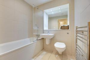 a bathroom with a toilet and a sink and a mirror at Principality Apartment in Cardiff