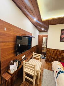 a living room with a flat screen tv on a wall at Sati Heights in Vashisht
