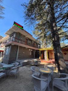 a building with tables and chairs in front of it at Sati Heights in Vashisht