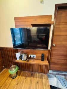 a tv sitting on top of a wooden stand at Sati Heights in Vashisht