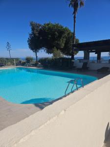 a swimming pool with blue water in a resort at Moriani Plage San-Nicolao Les Marines de Moriani in San-Nicolao