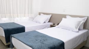a hotel room with two beds and a window at Nostro Hotel in Pato Branco
