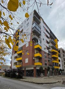 a building with yellow balconies on the side of it at E&O Apartment in Pogradec
