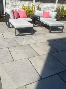 a group of benches sitting on a patio at Cozy Room at Willow House in Leyland