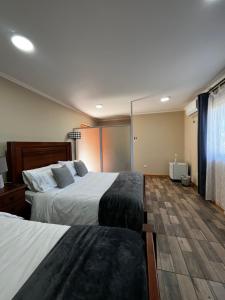 a hotel room with two beds and a window at Hotel Parcela Tierra Fértil in Coltauco