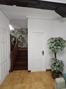 a hallway with a white door and a plant at Casa Gelín Verde in Santillana del Mar +5 photos