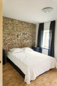 a bedroom with a large bed with a brick wall at De Moolt Vakantiewoningen in Eckelrade