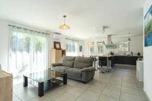 a living room with a couch and a table at La Parenthèse d'Hasparren - Avec Parking Privé in Hasparren
