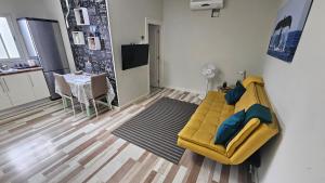 a living room with a yellow couch and a table at Apartamentos GARAKOTA in Telde +12 photos