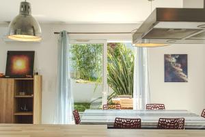 a dining room with a table and chairs and a window at La Parenthèse d'Hasparren - Avec Parking Privé in Hasparren