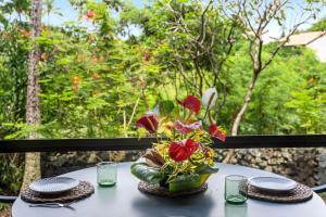 a table with a vase of flowers on it at Kona Pacific C317 in Kailua-Kona