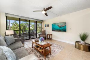 a living room with a couch and a table at Kona Pacific C317 in Kailua-Kona +24 photos