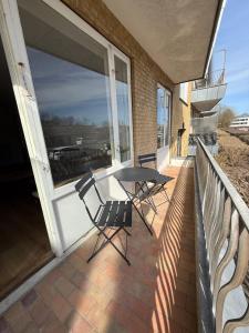 a patio with a table and chairs on a balcony at Completely renovated apartment, 6 sleeps in Herning