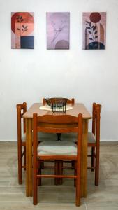 a wooden table and chairs in front of some paintings at Maria's Sweet Home in Chios