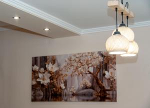 a painting of flowers on a wall with two lights at Maria's Sweet Home in Chios