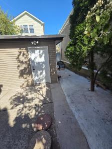 a door to a house with a dog laying on the driveway at Newly built Studio in Irvington