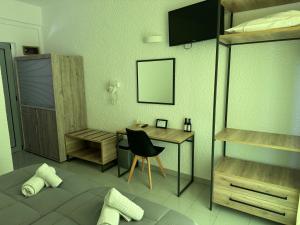 a bedroom with a bed and a desk with a chair at Georgina in Agia Marina Aegina