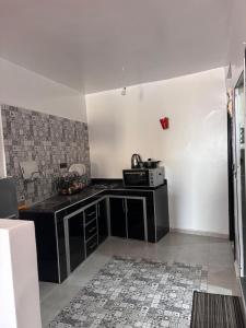 a kitchen with a black counter and a microwave at Yousef appartement in Taghazout