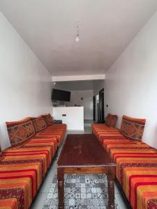 a room with two beds and a table in it at Yousef appartement in Taghazout