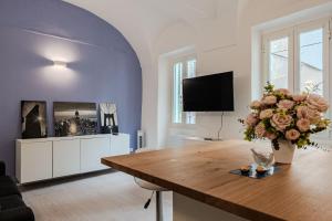 a living room with a table and a vase of flowers at Sole Mio in Sanremo