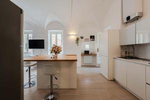 a kitchen with white cabinets and a counter with flowers on it at Sole Mio in Sanremo