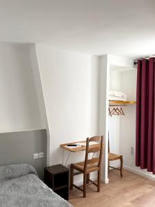 a bedroom with a bed and a table and a chair at Hotel de Nantes in Paris +15 photos