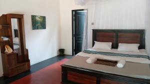 a bedroom with a large bed with a wooden headboard at Kite Brothers Resort in Kalpitiya