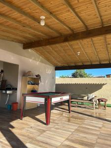 a ping pong table in the middle of a patio at Casa com piscina aquecida e quadra de vôlei in Osório